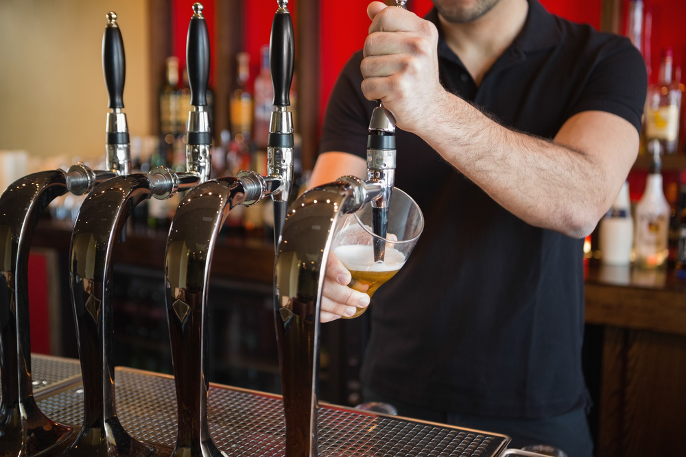 Barkeeper pulling a pint of beer behind the bar